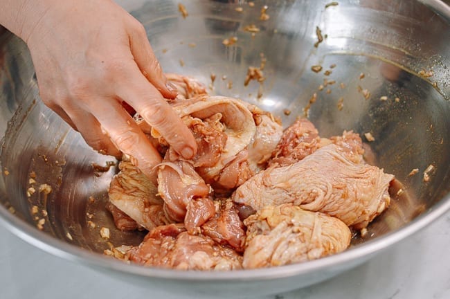 Working marinade ingredients into chicken, thewoksoflife.com