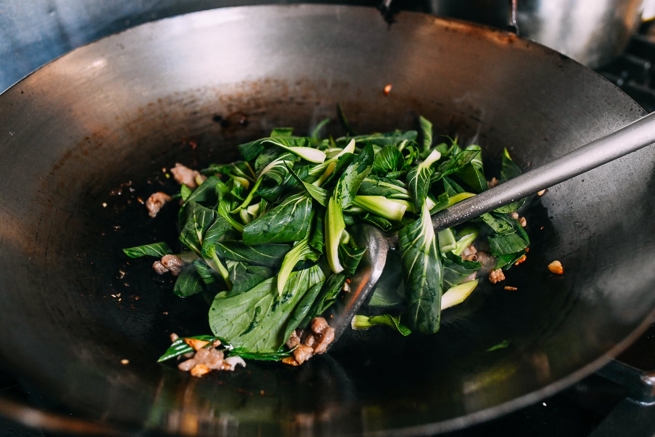 Adding bok choy to wok