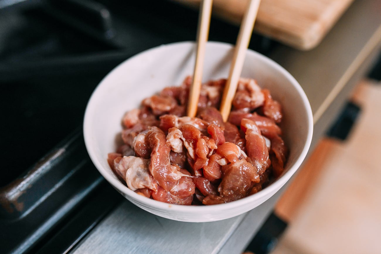Marinated julienned pork in bowl with chopsticks
