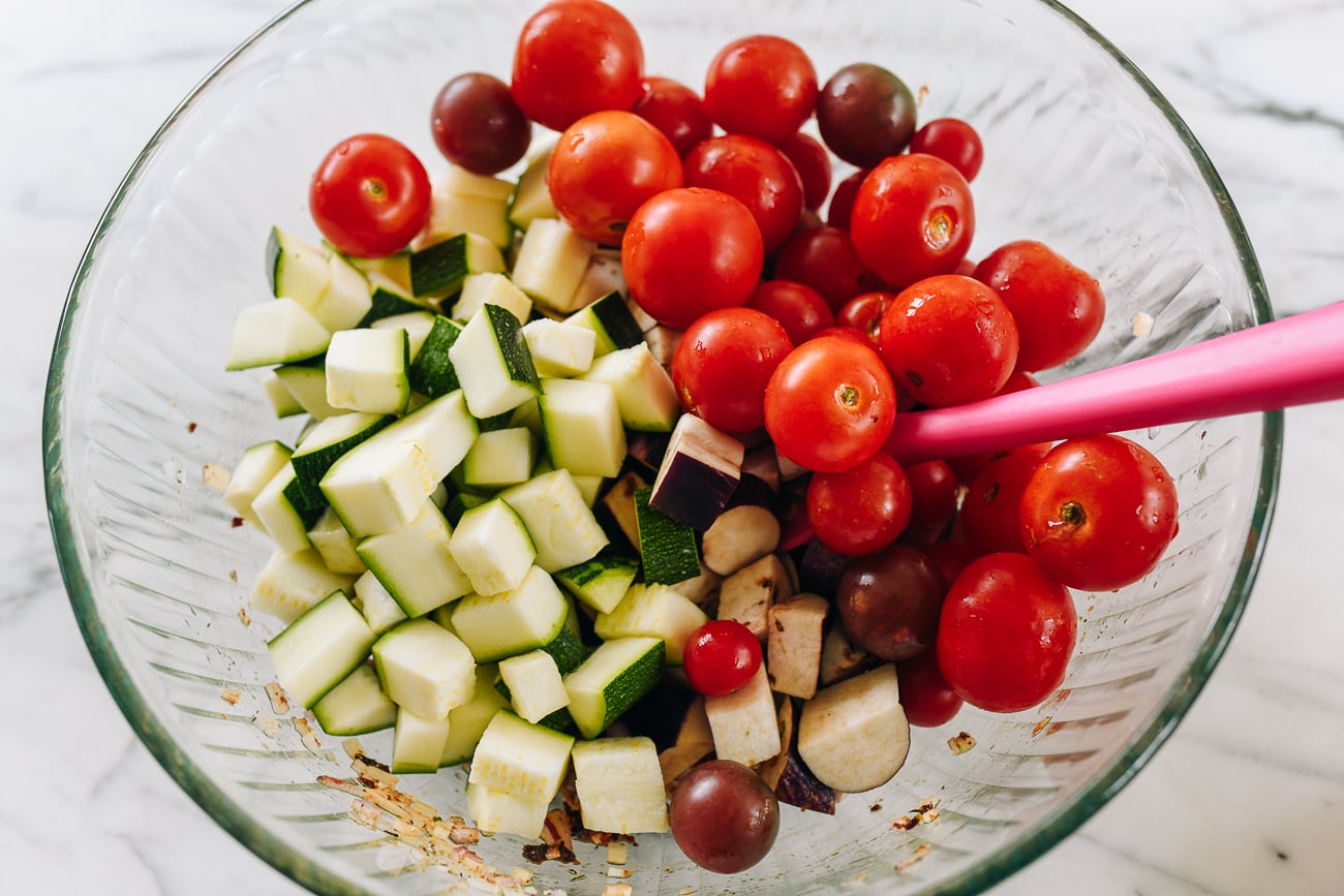 eggplant, zucchini, and cherry tomatoes in glass mixing bowl