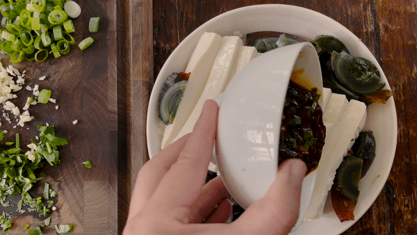 pouring sauce over soft tofu