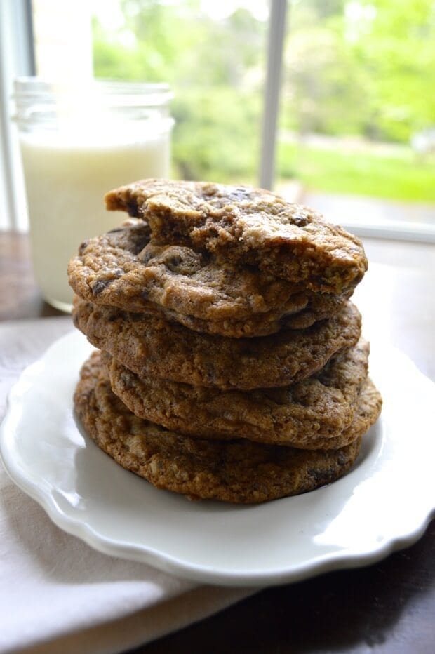 Pile of chocolate chip nut cookies with glass of milk