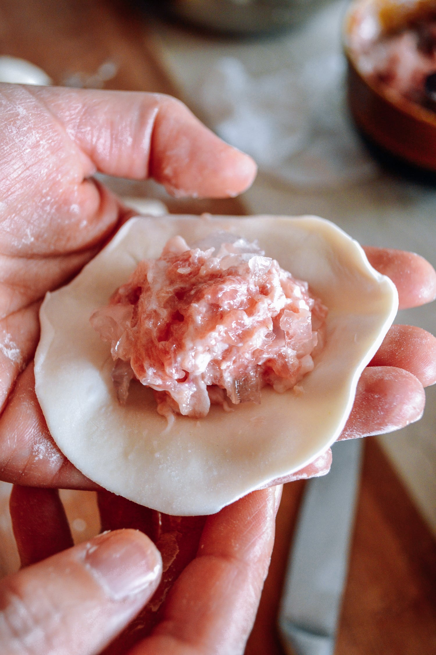 Pork and aspic filling on thin dumpling wrapper, by thewoksoflife.com