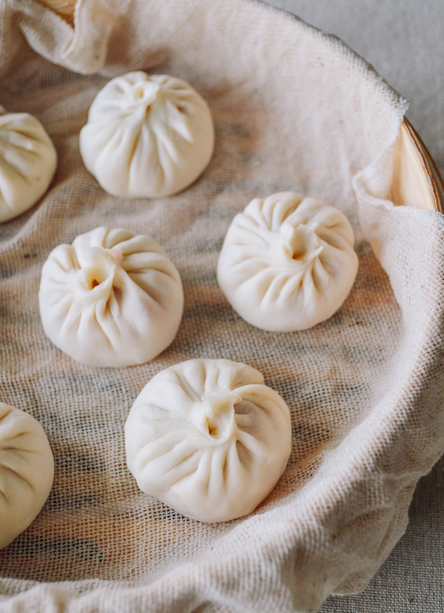 Soup dumplings in steamer before cooking, by thewoksoflife.com