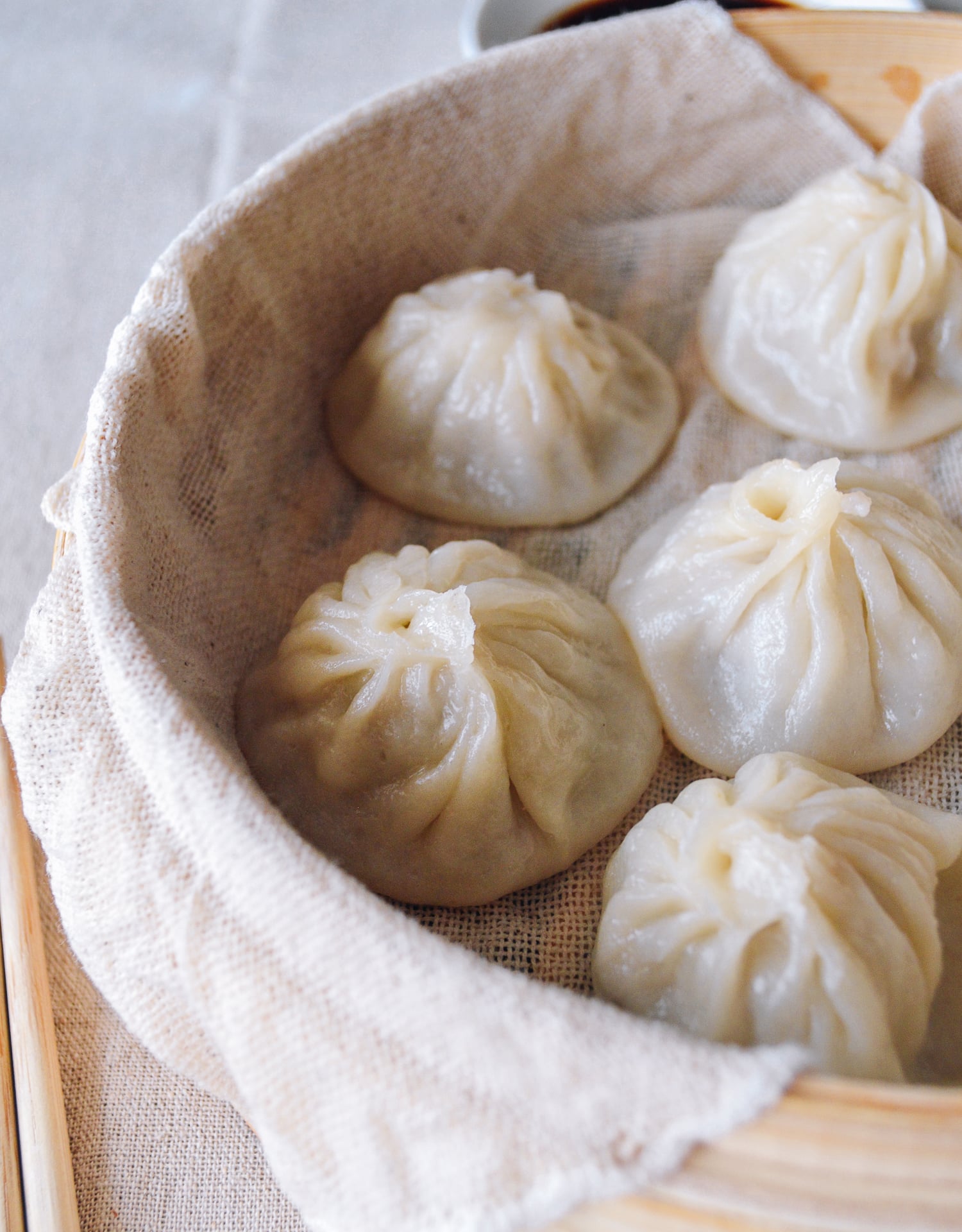 Dipping xiaolongbao into black vinegar and ginger, by thewoksoflife.com