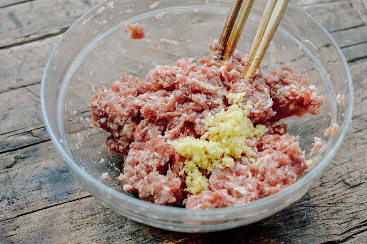 Mixing ground pork dumpling filling, by thewoksoflife.com