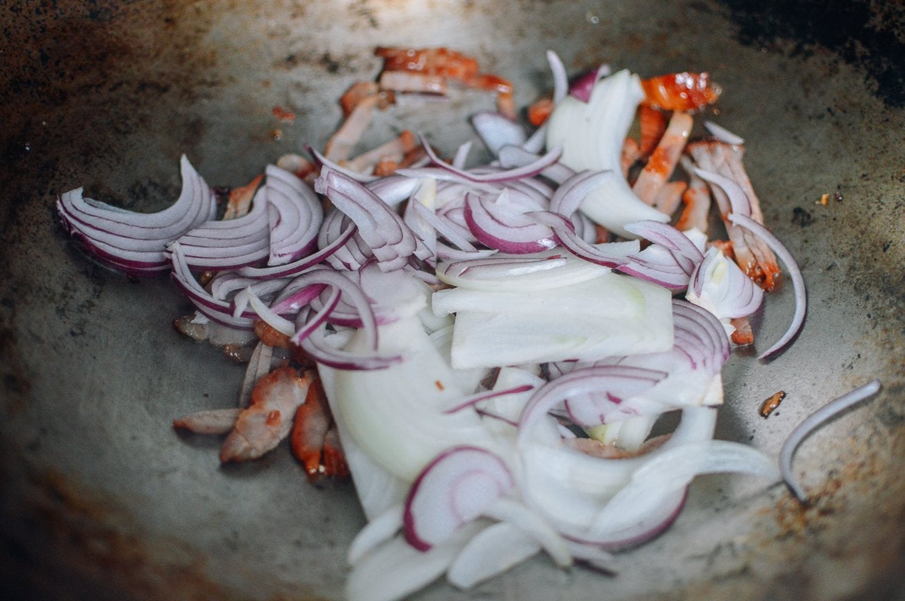 onions and char siu in wok