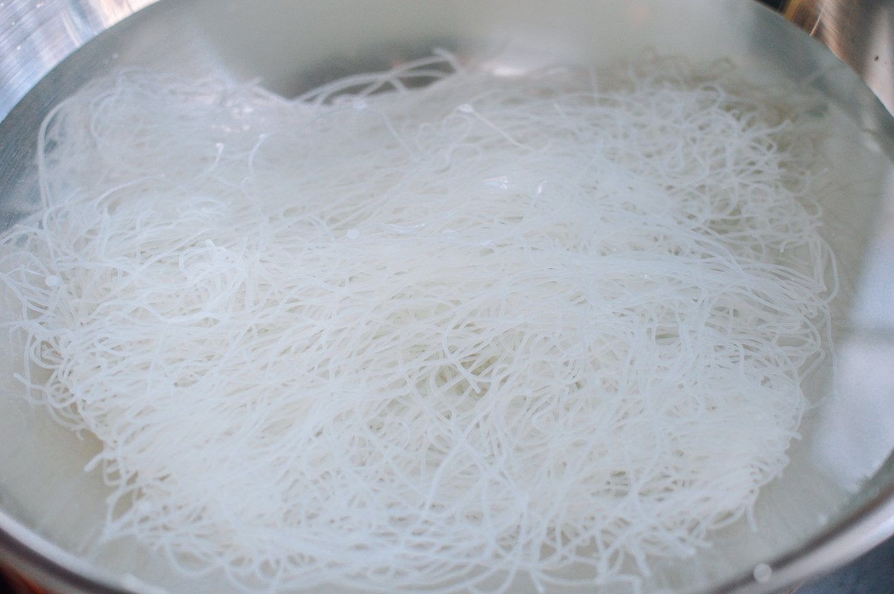 soaking mei fun rice noodles in a metal bowl of water