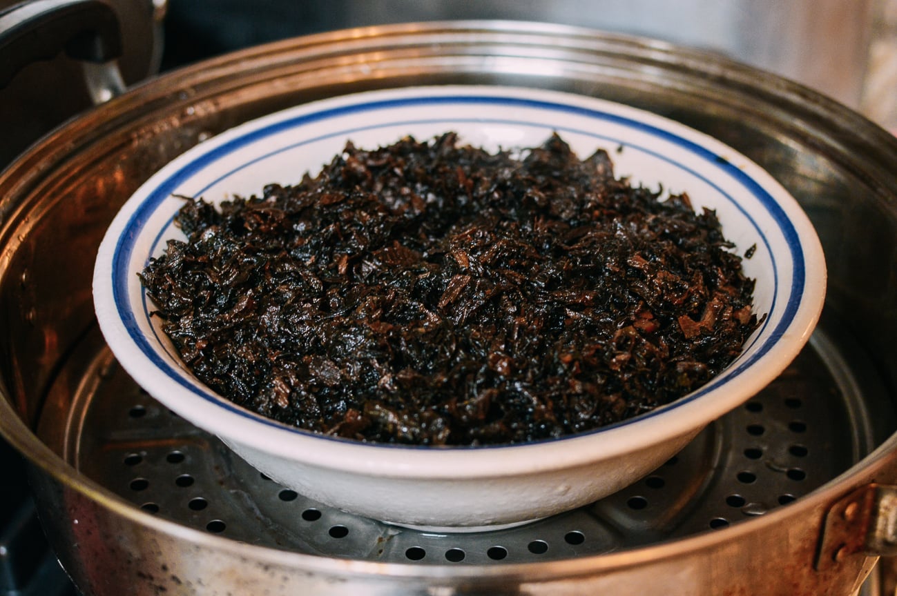 Bowl of pork belly and moy choy in steamer