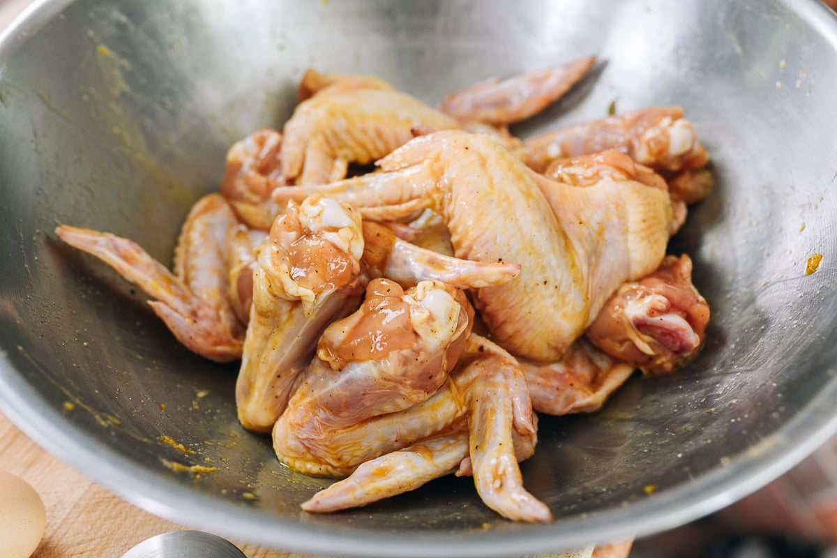 Marinated chicken wings in metal bowl