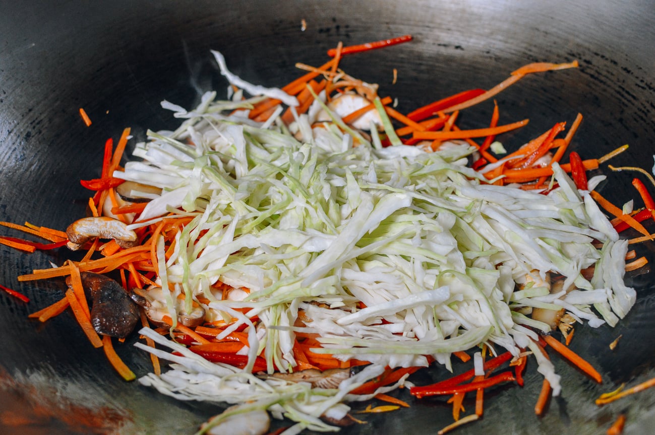 adding cabbage to wok