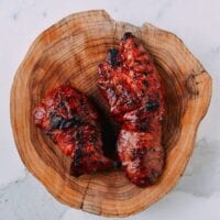 Grilled char siu on wood cutting board