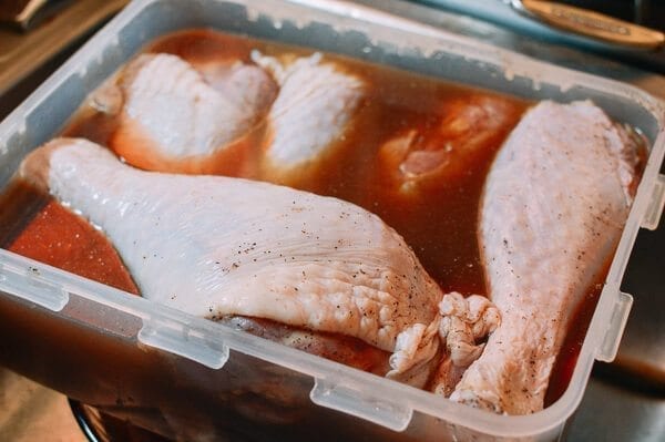 turkey legs in plastic container with brine