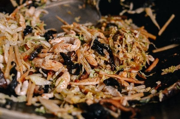 Stir-frying chicken with vegetables in wok, by thewoksoflife.com