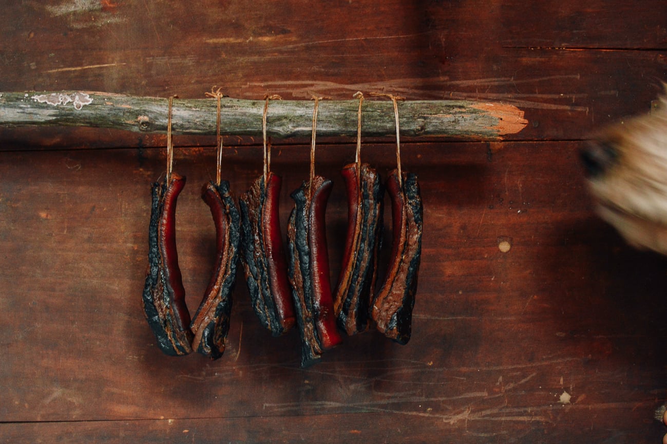 Pork Belly hanging from a sturdy stick