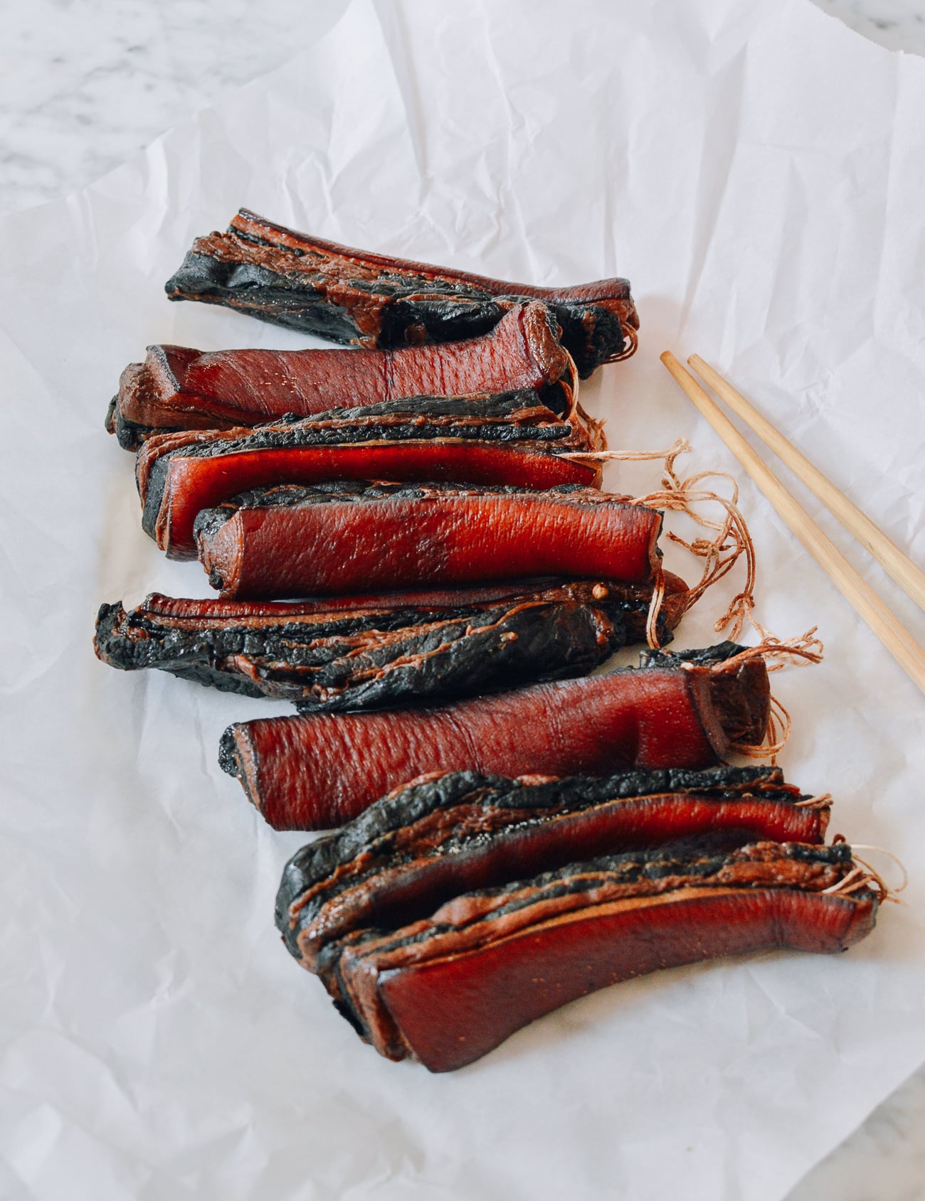Cured pork belly pieces on parchment paper
