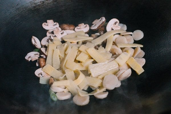 Adding mushrooms and bamboo shoots, by thewoksoflife.com