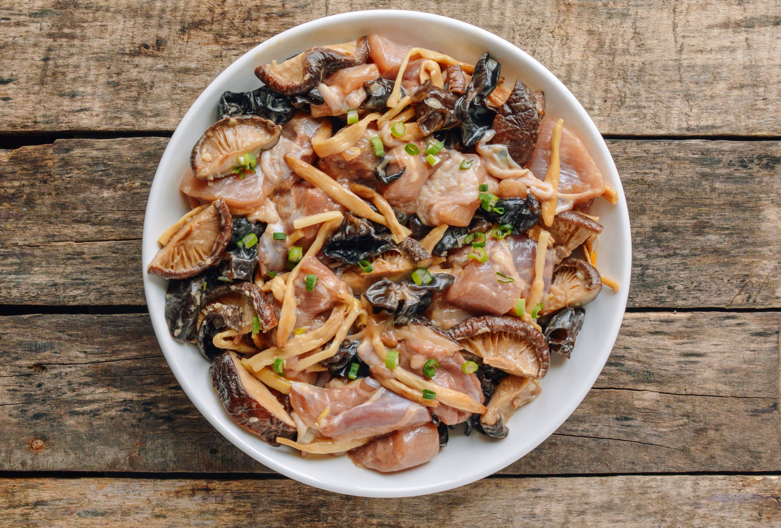 marinated chicken thighs with wood ear, mushroom, and lily flower on white dish