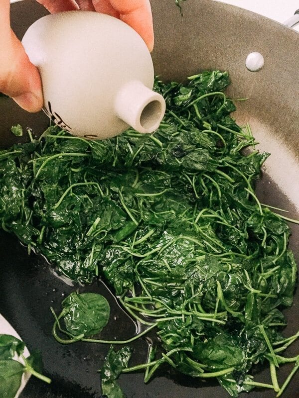 Sautéed Edible Clover (Chao Tou - 炒头) - bai jiu poruing into clover and wok, by thewoksoflife.com