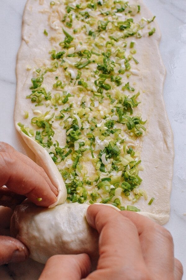 wrapping scallion in dough for Shanghai Scallion Pancakes, by thewoksoflife.com