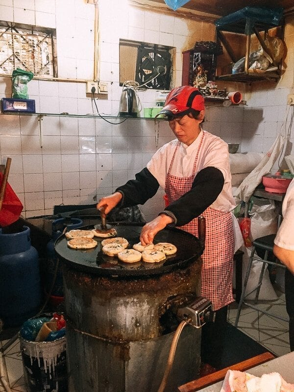 woman frying Shanghai Scallion Pancakes by thewoksoflife.com