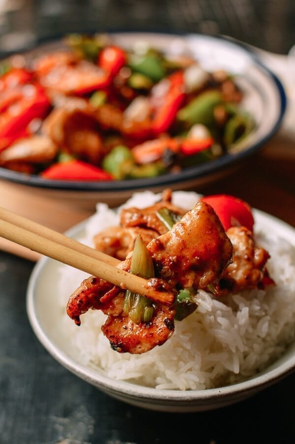 Chopsticks picking up a piece of chicken with black bean sauce, thewoksoflife.com