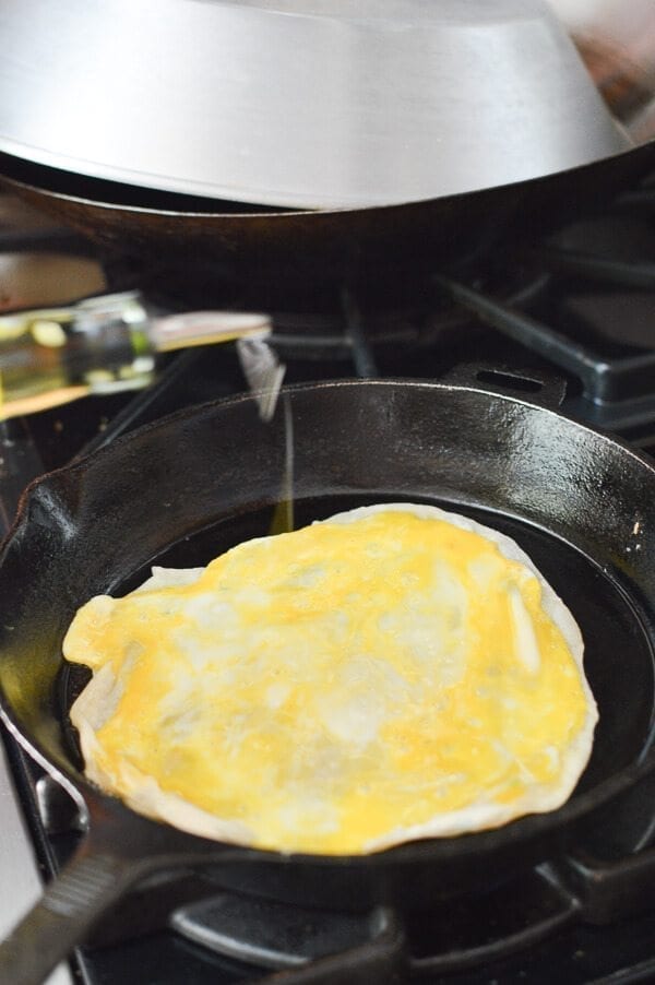 adding oil onto Jidan Bing in pan, by thewoksoflife.com