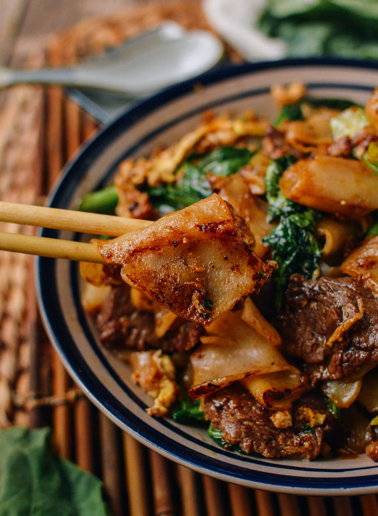 Picking up pad see ew noodles with chopsticks