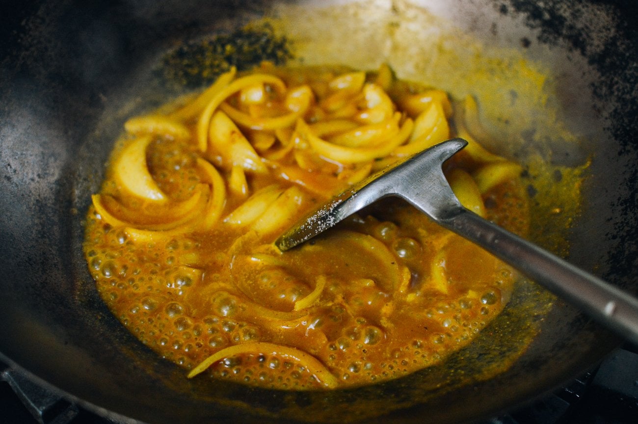 making curry sauce with onions in wok