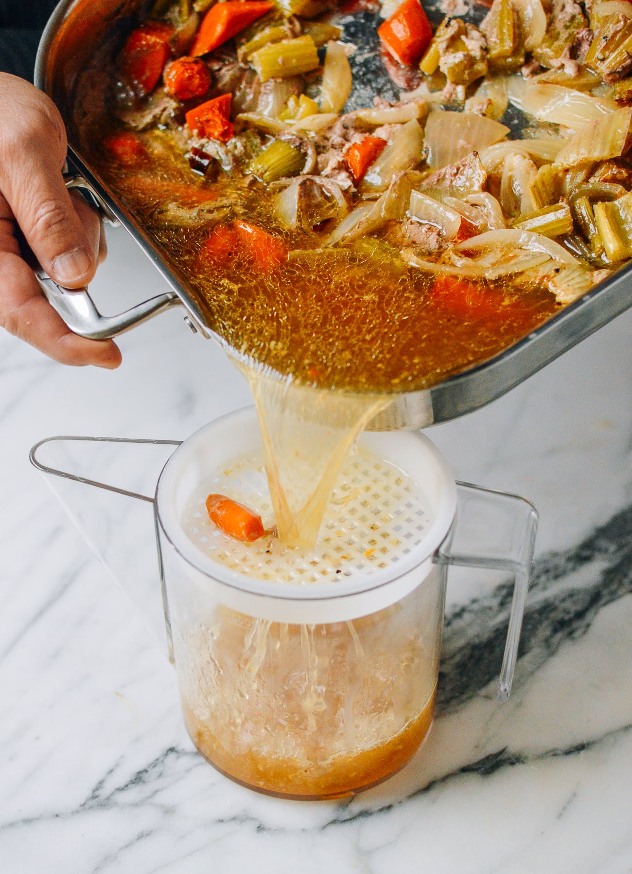 pouring juices from turkey roasting pan into fat separator