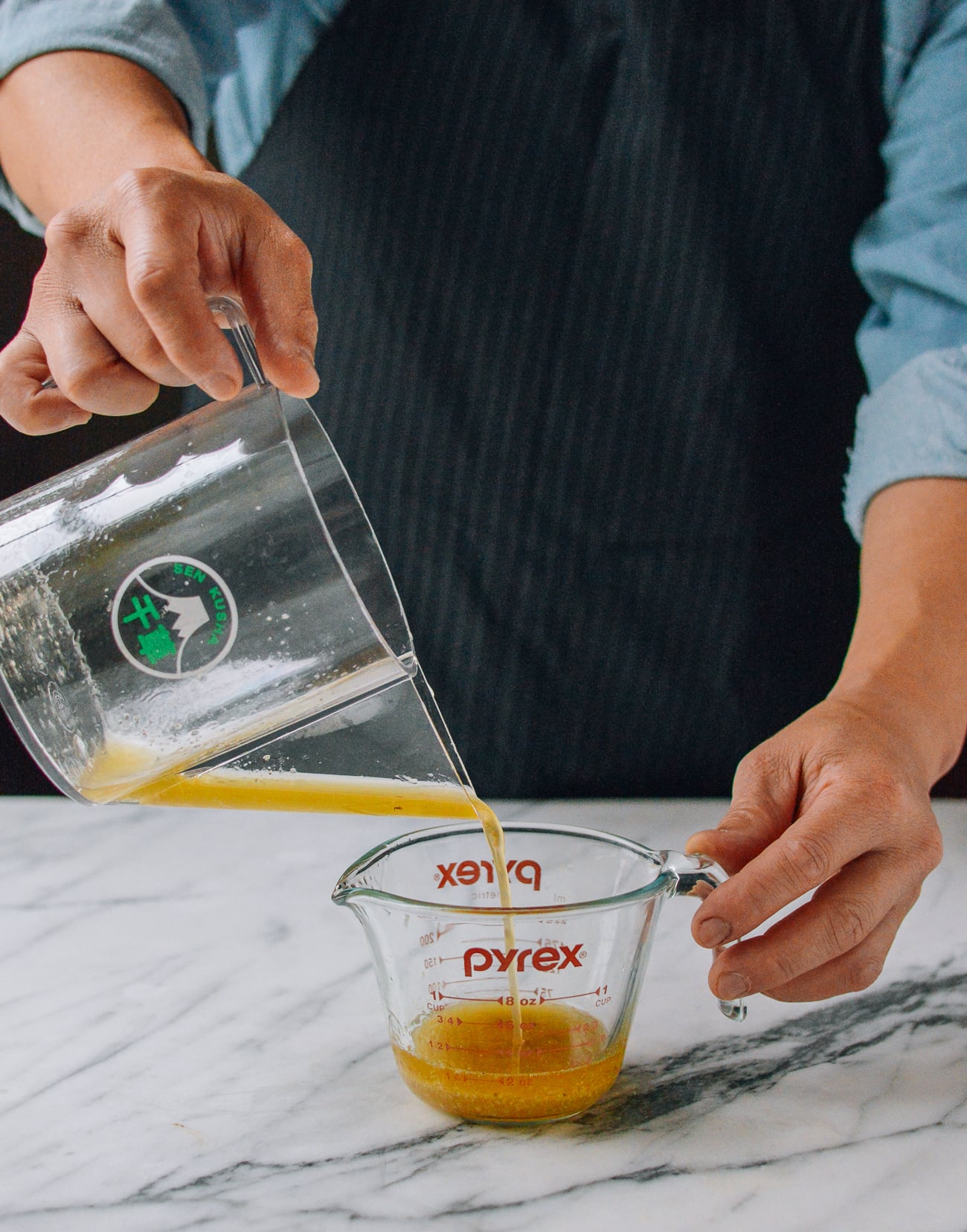 pouring turkey fat from fat separator into measuring cup