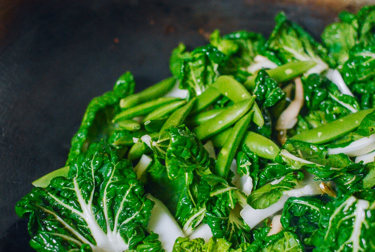 snap peas and bok choy in wok