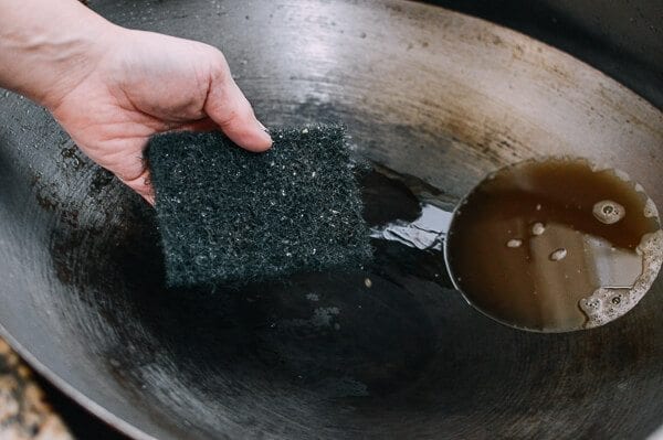 scrubbing wok with scouring pad