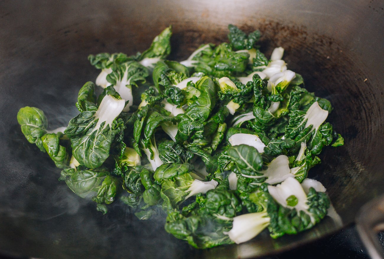 adding bok choy to wok
