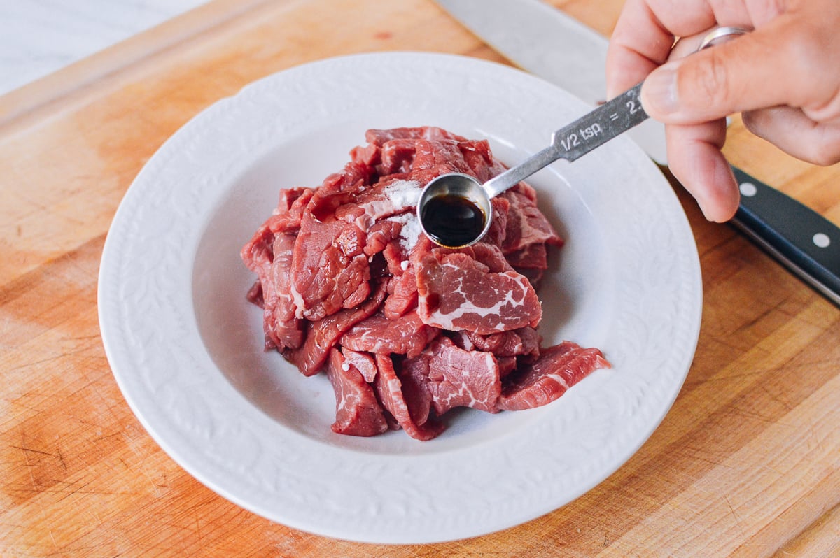 adding oyster sauce marinade to beef by thewoksoflife.com
