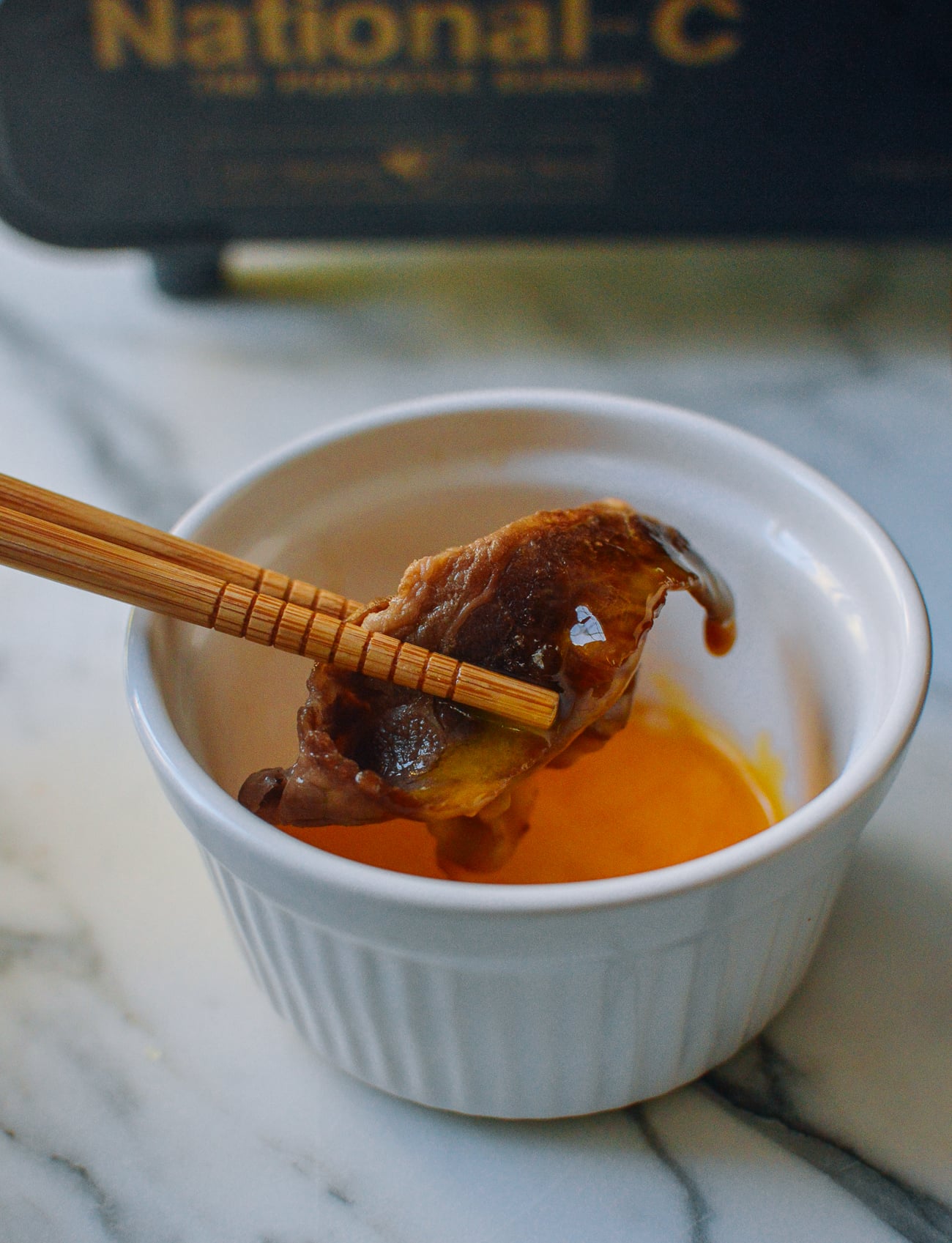 dipping thinly sliced beef in raw egg yolk