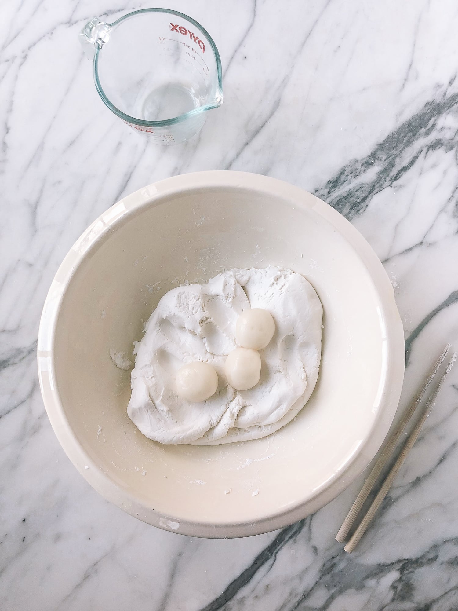 adding cooked rice balls to raw rice flour dough in bowl, by thewoksoflife.com
