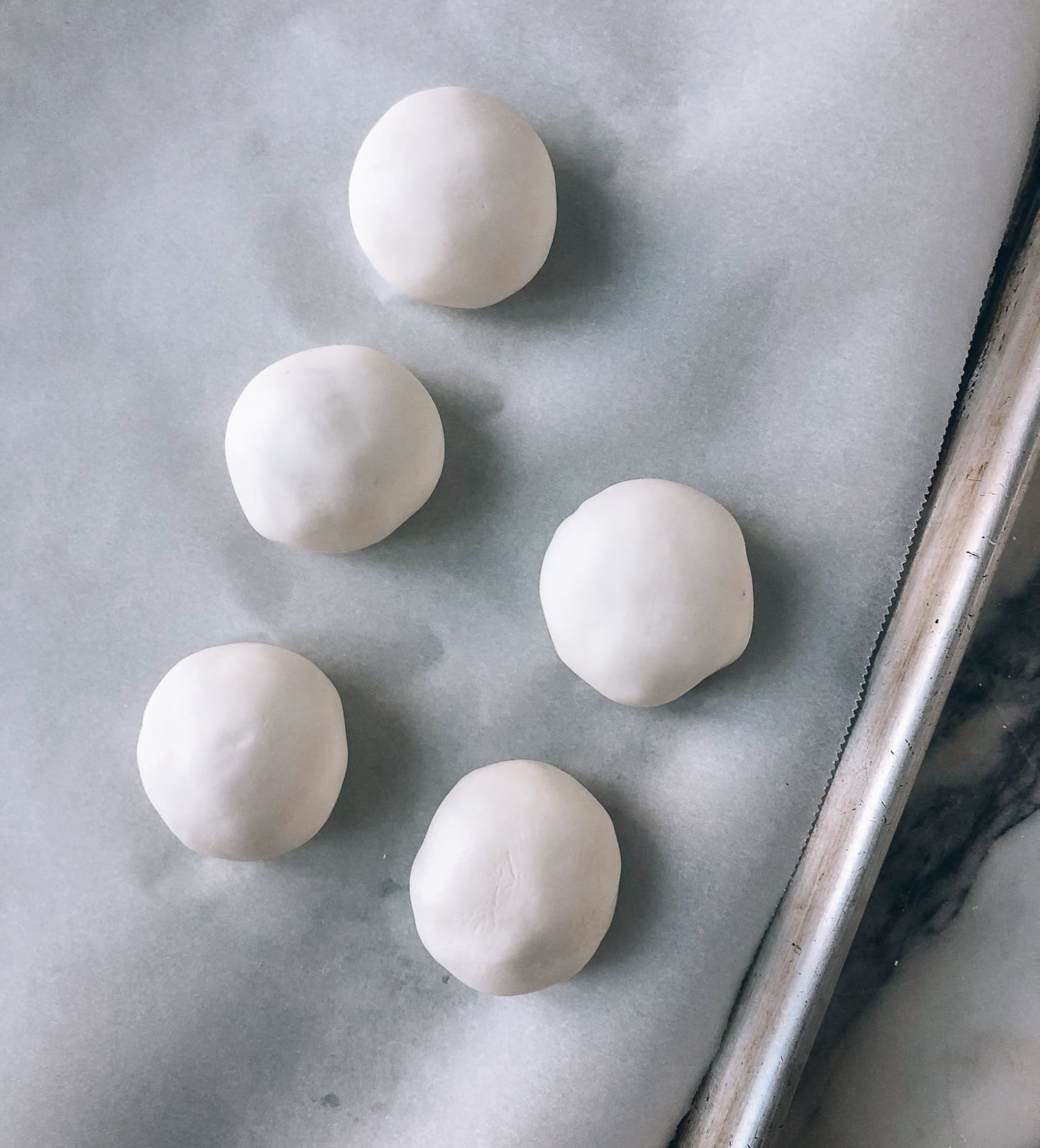 uncooked Savory Tang Yuan sitting on parchment paper, by thewoksoflife.com