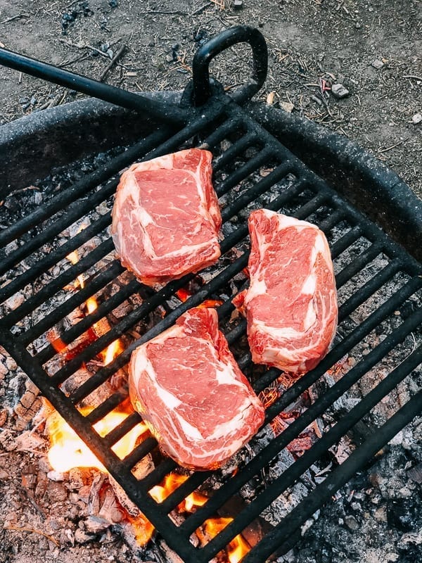 Grilling steak on a fire ring in campground, thewoksoflife.com