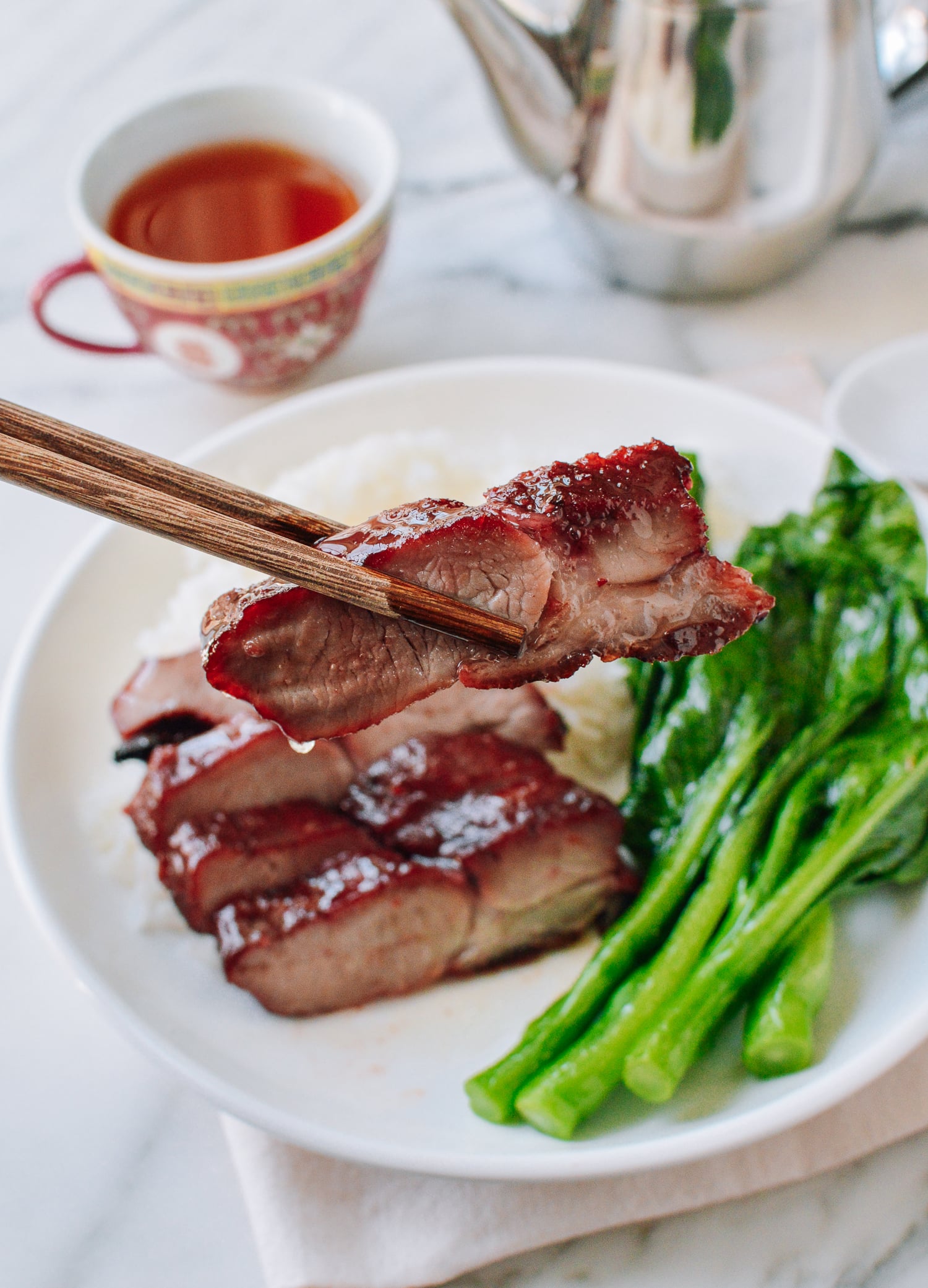 Picking up char siu with chopsticks, thewoksoflife.com