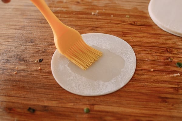 Brushing dumpling wrapper with oil, thewoksoflife.com