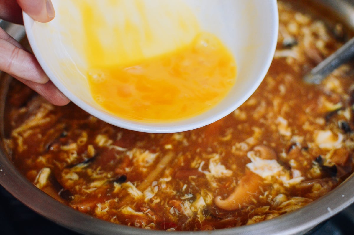 Adding egg to hot and sour soup, thewoksoflife.com