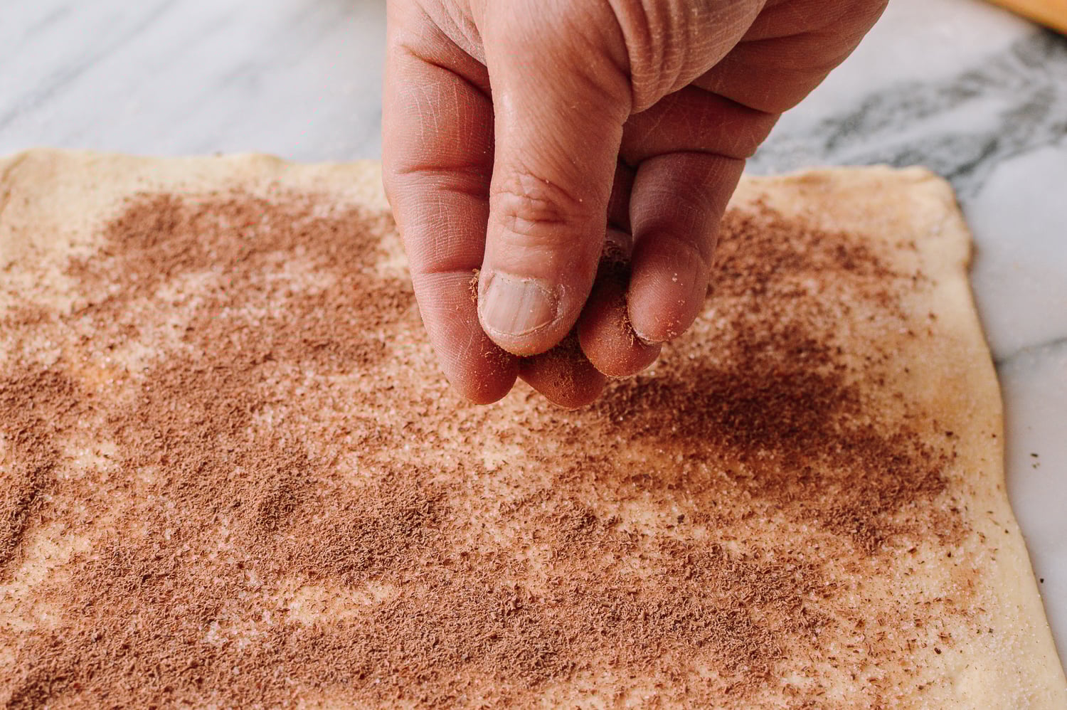 Spreading grated chocolate over puff pastry, thewoksoflife.com