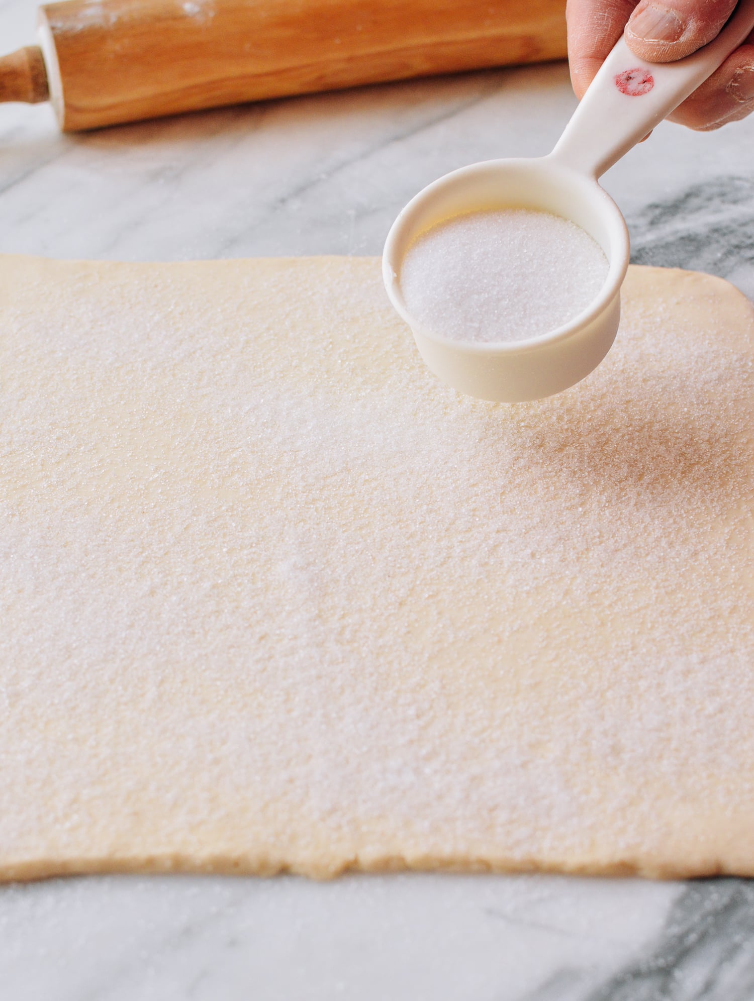 Spreading sugar on top of puff pastry dough, thewoksoflife.com