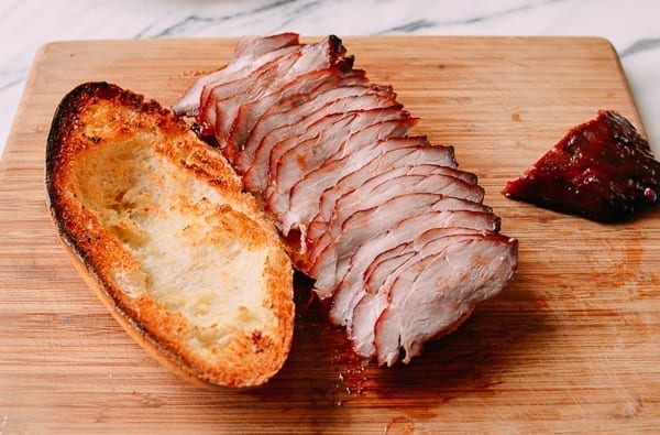 Adding sliced pork to sandwich, thewoksoflife.com