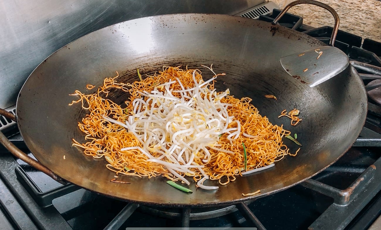 adding bean sprouts to pan-fried noodles