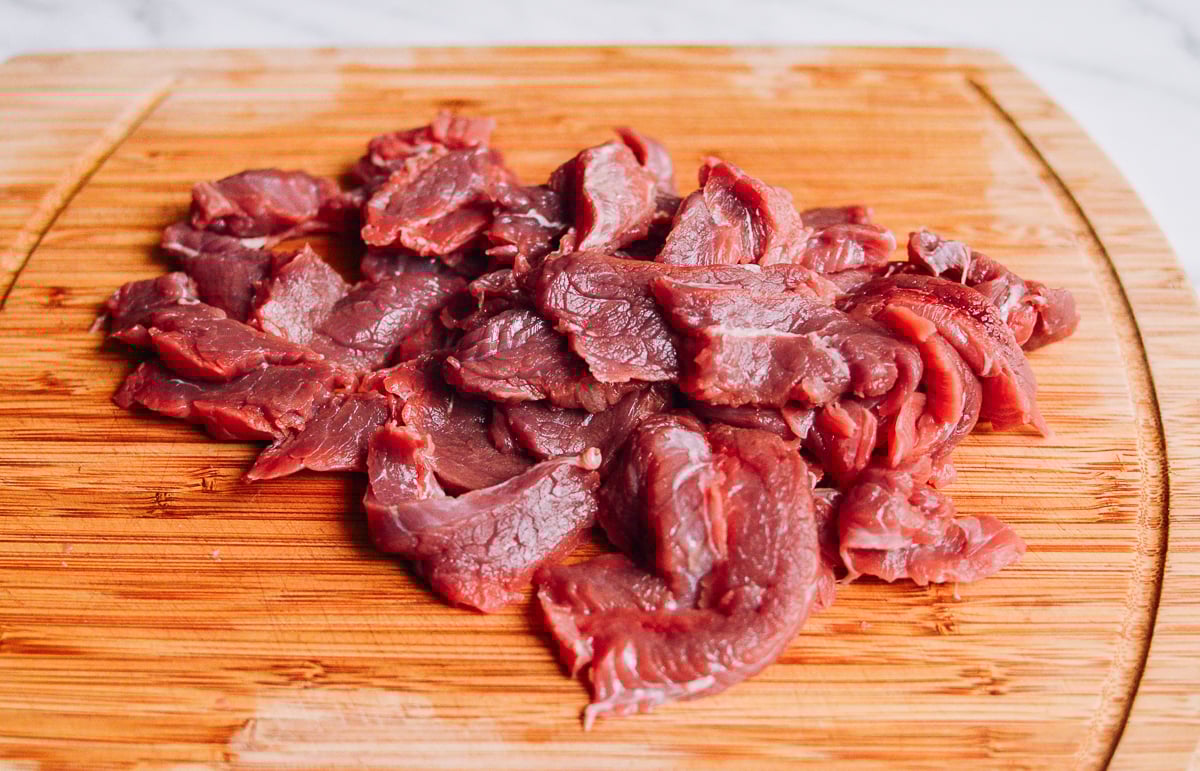 beef flank steak slices on cutting board by thewoksoflife.com