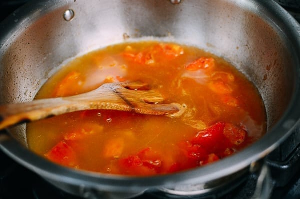 Tomatoes, stock, and seasonings in pot, thewoksoflife.com