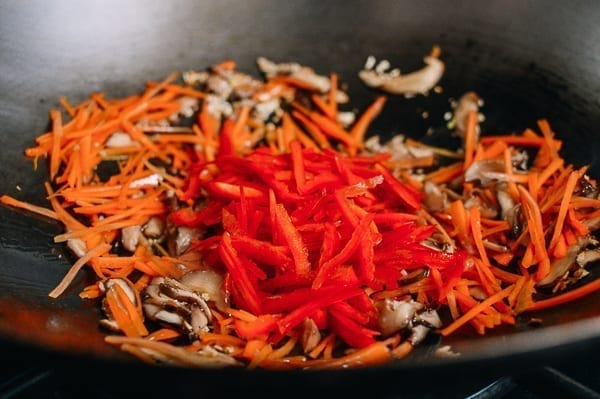 Adding julienned bell peppers to wok, thewoksoflife.com