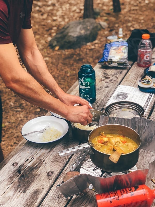 Cooking chicken curry over camping stove, thewoksoflife.com